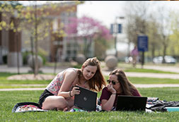 Photo of two students lying on the grass. Links to Tangible Personal Property